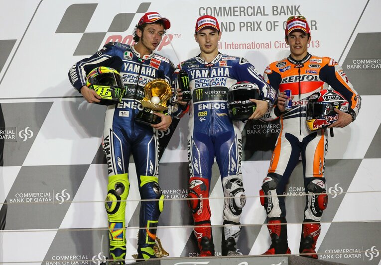 2013年開幕戦のカタールGPで3位となり、ホルヘ・ロレンソ（中央）、ロッシ（左）とともに表彰台に上ったマルケス　©Satoshi Endo