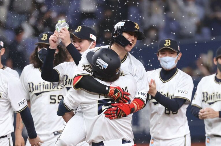 劇的な「サヨナラバスター」を決めてチームメートに祝福される小田 ／ photograph by JIJI PRESS