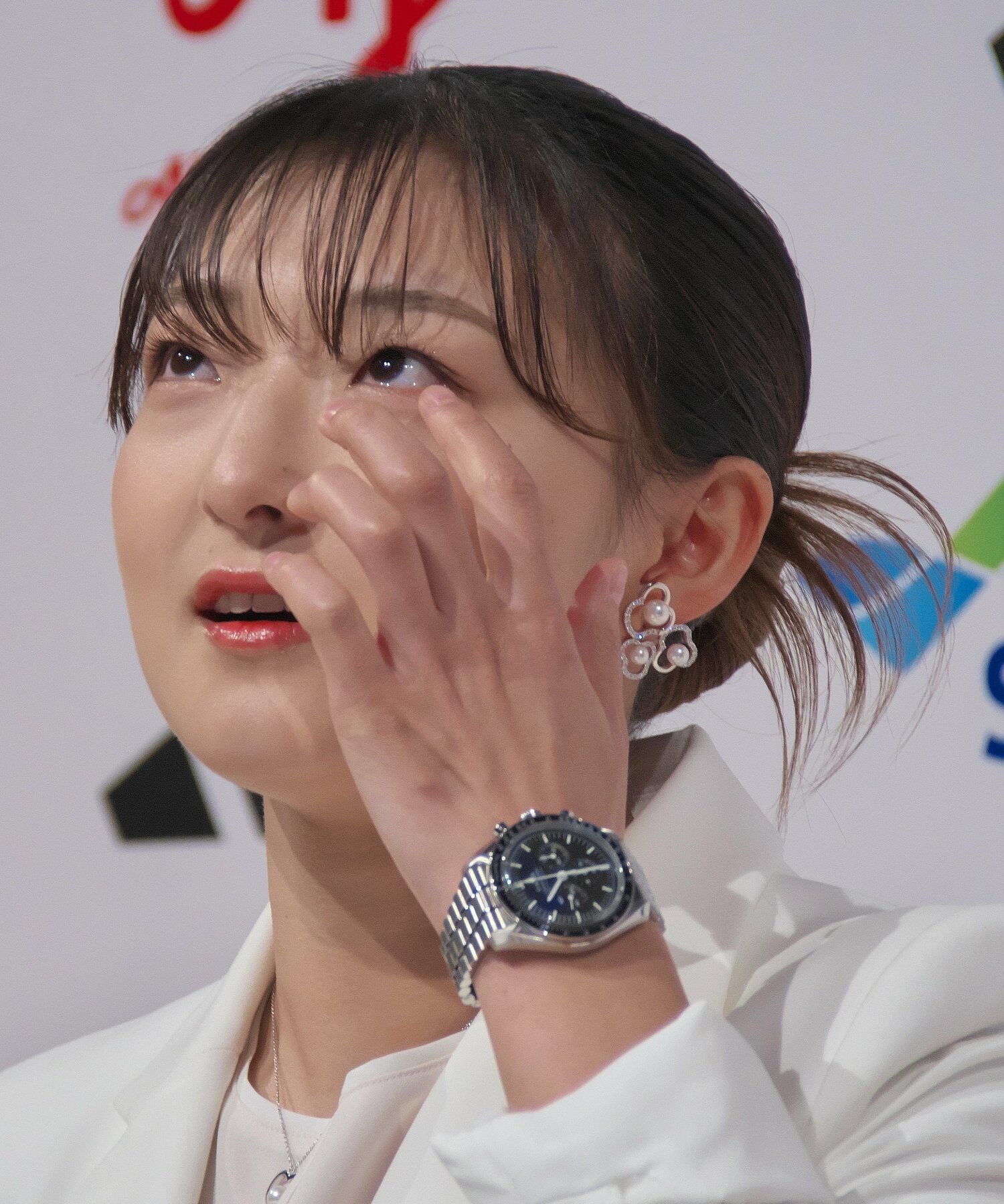 引退会見でメッセージ映像を見て涙を拭う坂本花織 ©️AFLO