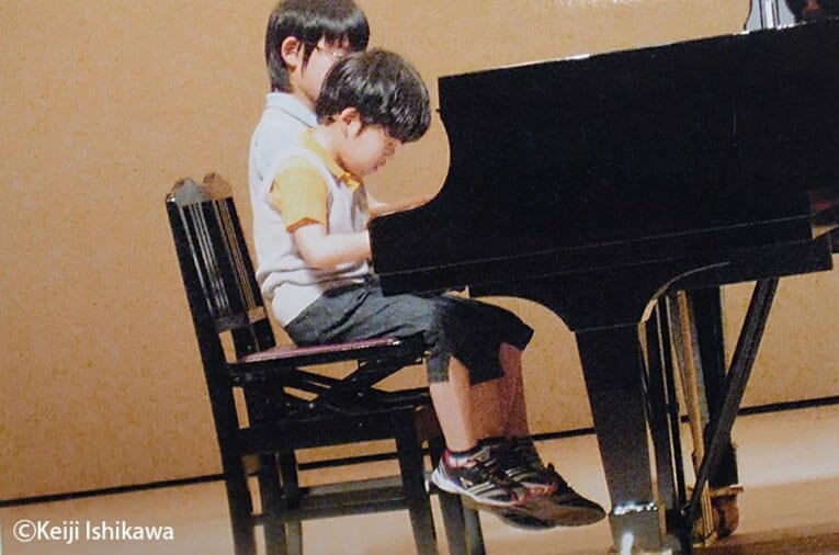幼い頃の藤井聡太竜王がピアノを弾く姿※写真を複写 ／ photograph by Keiji Ishikawa