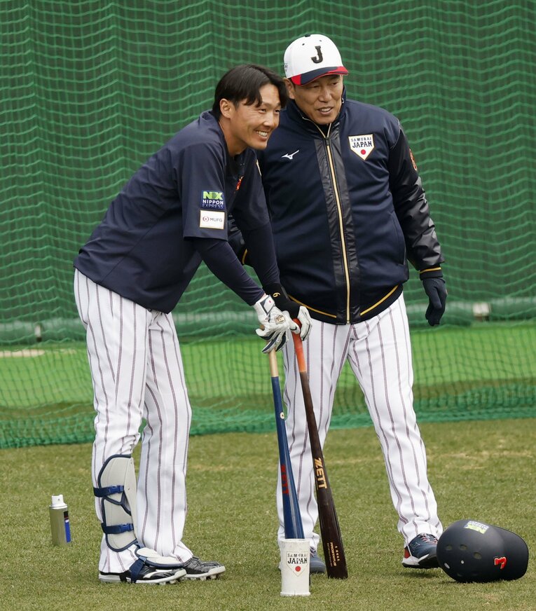 練習中に、笑顔で言葉を交わす源田と井端監督　©KYODO