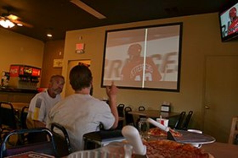 ピザハウスでアイスホッケーの試合を観るRummonkey（左）。 