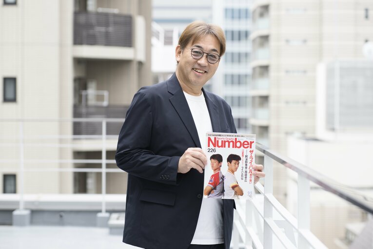 当時彼らを「ザ・ライバル」として特集したNumber誌を手にする西崎氏。ふたりの娘さん同士で同じポーズの写真を撮ったこともあるとか！　©Hirofumi Kamaya