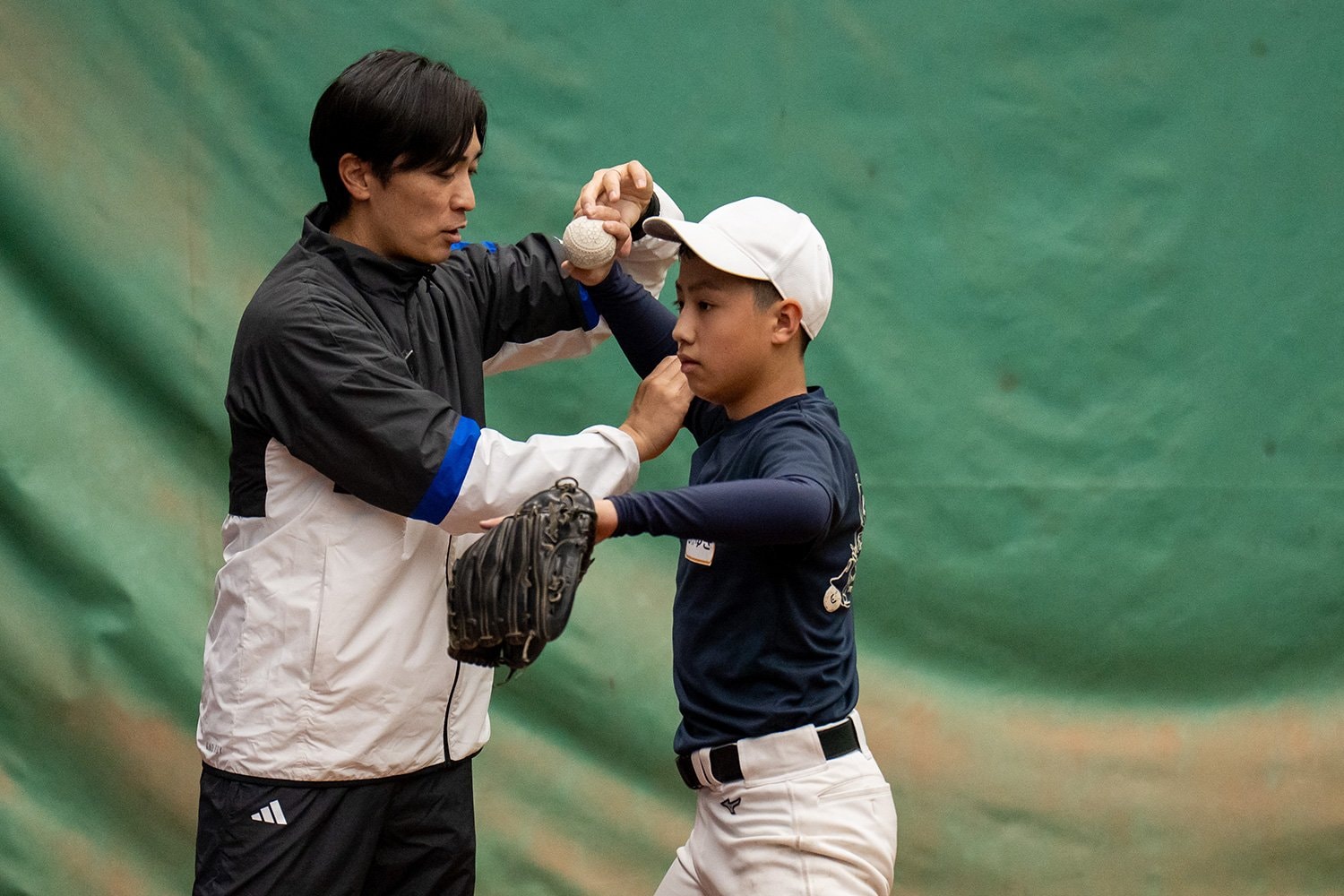 ブルペンで投手コースの子どもたちを丁寧に指導