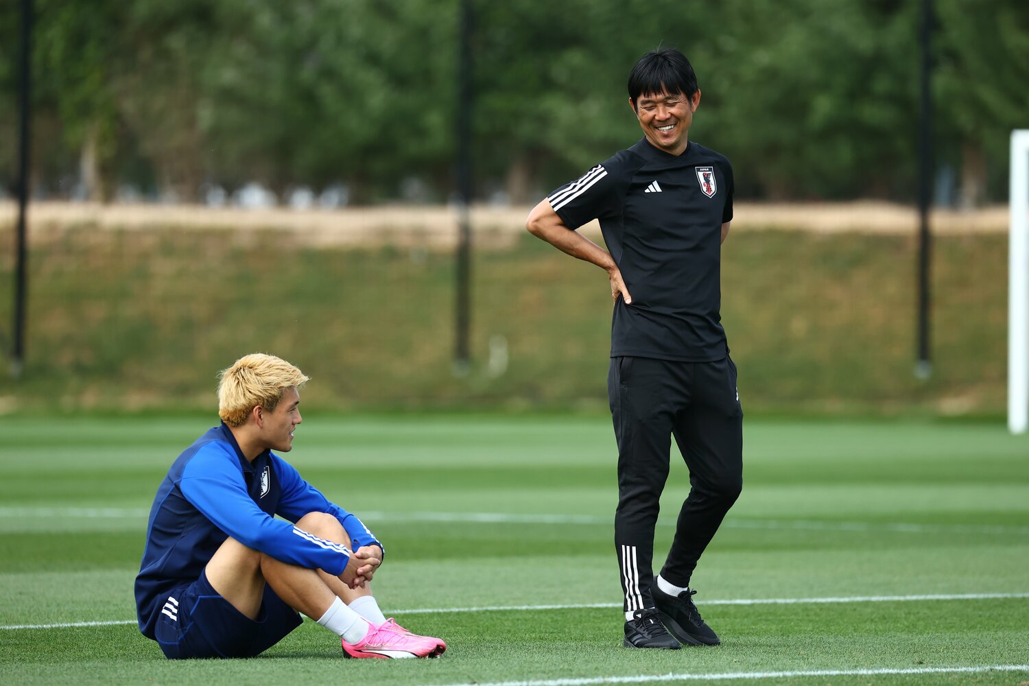 アジアカップの練習で。グラウンドで話し込む森保監督と堂安律　©JFA／AFLO