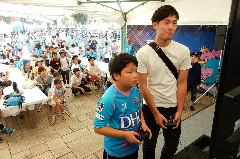 『FIFA』で対戦する子供と青年。見ず知らずの人間がeスポーツを通じて交流できるのは、実際のサッカーと同じ面白さなのかもしれない。 ／ photograph by Negi Yagi
