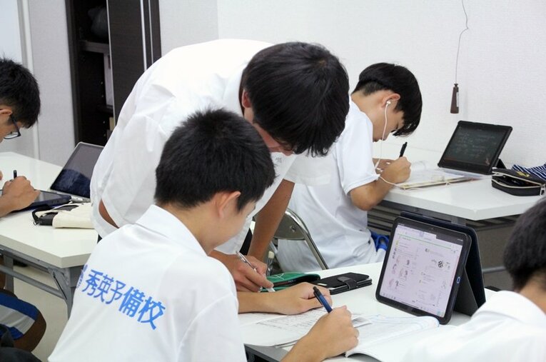 中学生に勉強を教える清水東高校の生徒 ／ photograph by Jun Aida