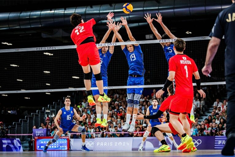 身長207cmのルッソ（19番）らの高いブロックの上からスパイクを打ち込む高橋藍　©︎Volleyball World