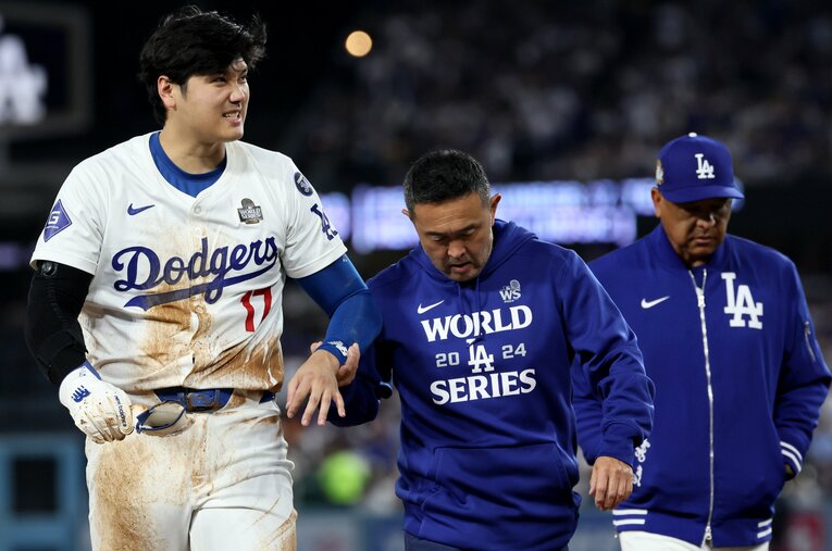 駆け寄るトレーナーに脱臼したことを自ら伝えた大谷翔平。ニューヨークに移動して迎えるWS第3戦への出場はなるか ／ photograph by Getty Images