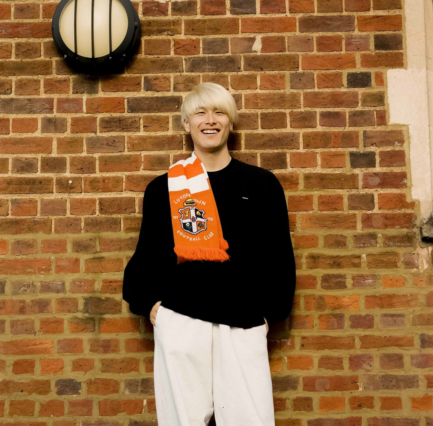 サポーターからもらったマフラーを身につけて写真撮影に応じる橋岡大樹　©︎Yudai Emmei