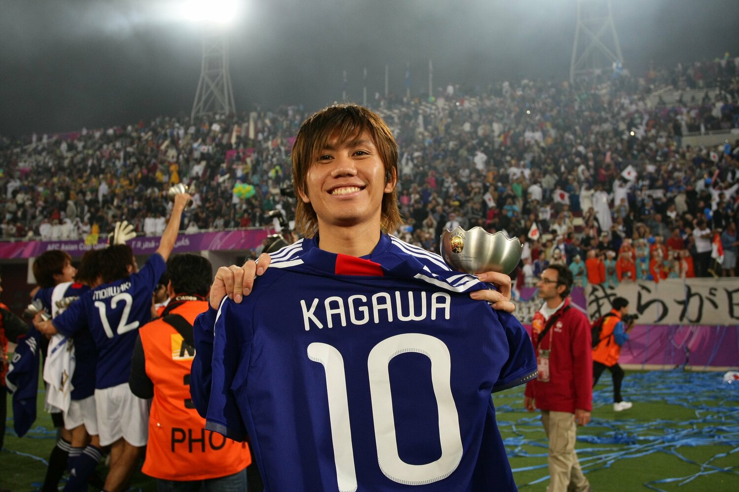 2011年アジア杯優勝後、負傷離脱した香川真司のユニフォームを手にして笑顔の柏木　©JFA/AFLO