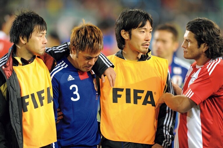 この時の記憶が全くない、と語る駒野。松井（左）、阿部に支えられ、会場を後に　©️Kaoru Watanabe/JMPA