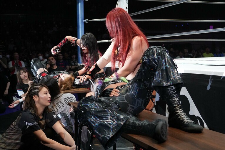 場外の机上で林下詩美から焼酎を浴びせられる鈴季すず。手前は舞華とジュリア