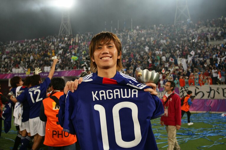 2011年アジア杯優勝後、負傷離脱した香川真司のユニフォームを手にして笑顔の柏木　©JFA/AFLO