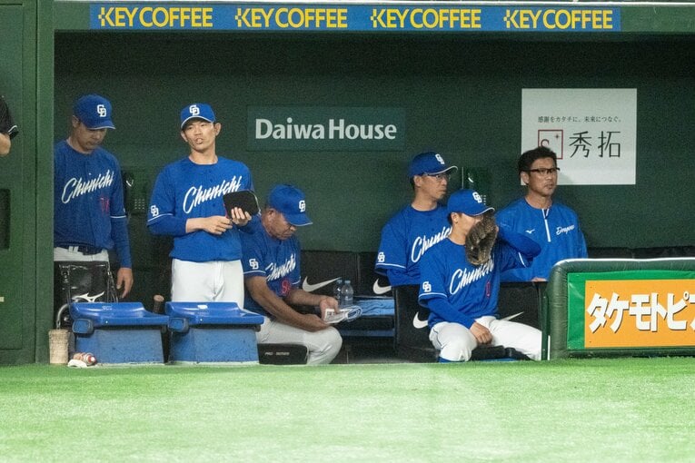 中日守備時のベンチ。井上監督は後方で座る。内野守備走塁コーチの堂上直倫（前方左）とバッテリーコーチの大野奨太（前方中央）が立つ。井上監督の右隣には投手コーチの山井大介　©Miki Fukano