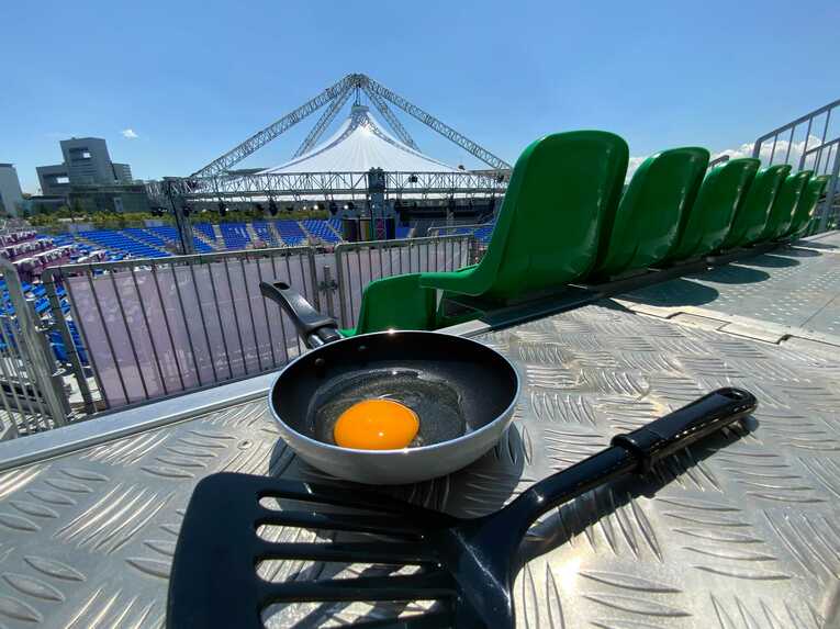 この日の最高気温は34.2℃。無観客実施で使用予定のないスタンドがとんでもない熱さだ。そこで、スタンド床の鉄板にフライパン（しっかりフライパン返しも用意）を設置。目玉焼きチャレンジを試みた
