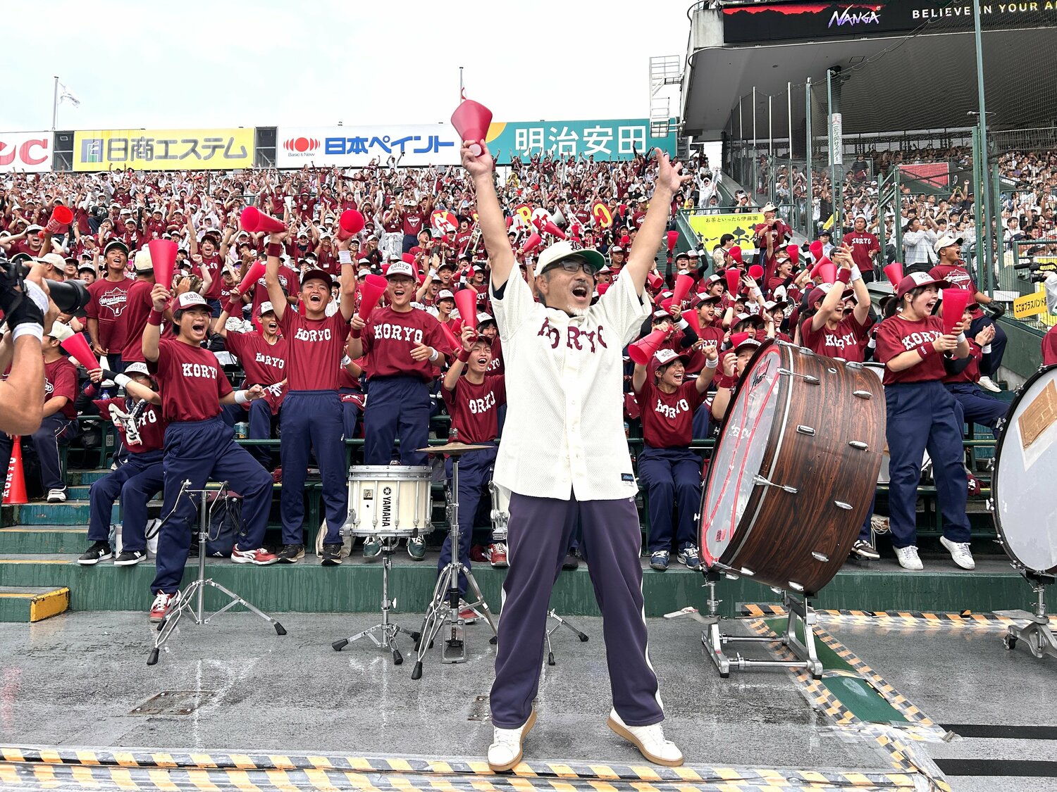 小枝守前監督の形見である帽子をかぶり、甲子園34年ぶりの勝利に喜びを爆発させる、拓大紅陵吹奏楽部顧問・吹田正人氏 ©Yukiko Umetsu