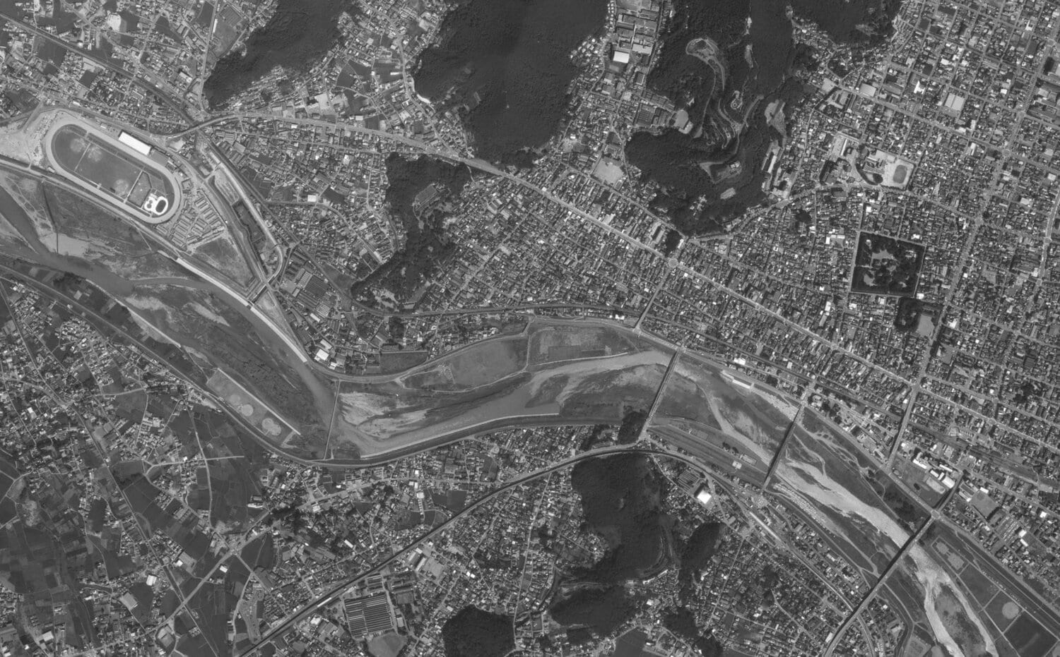 1980年の足利駅~足利競馬場付近の航空写真。左上に足利競馬場が見える。中央を流れるのが渡良瀬川。渡良瀬橋は右から3本目。足利駅は右下に写っている 出典:国土地理院の空中写真