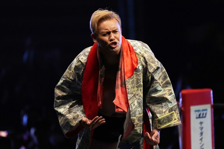 厳しい表情でコーナーに立つオカダ