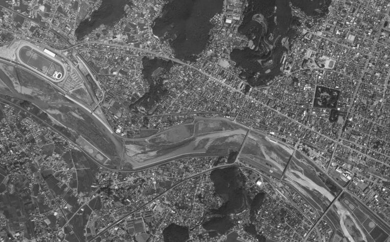 1980年の足利駅～足利競馬場付近の航空写真。左上に足利競馬場が見える。中央を流れるのが渡良瀬川。渡良瀬橋は右から3本目。足利駅は右下に写っている　出典：国土地理院の空中写真