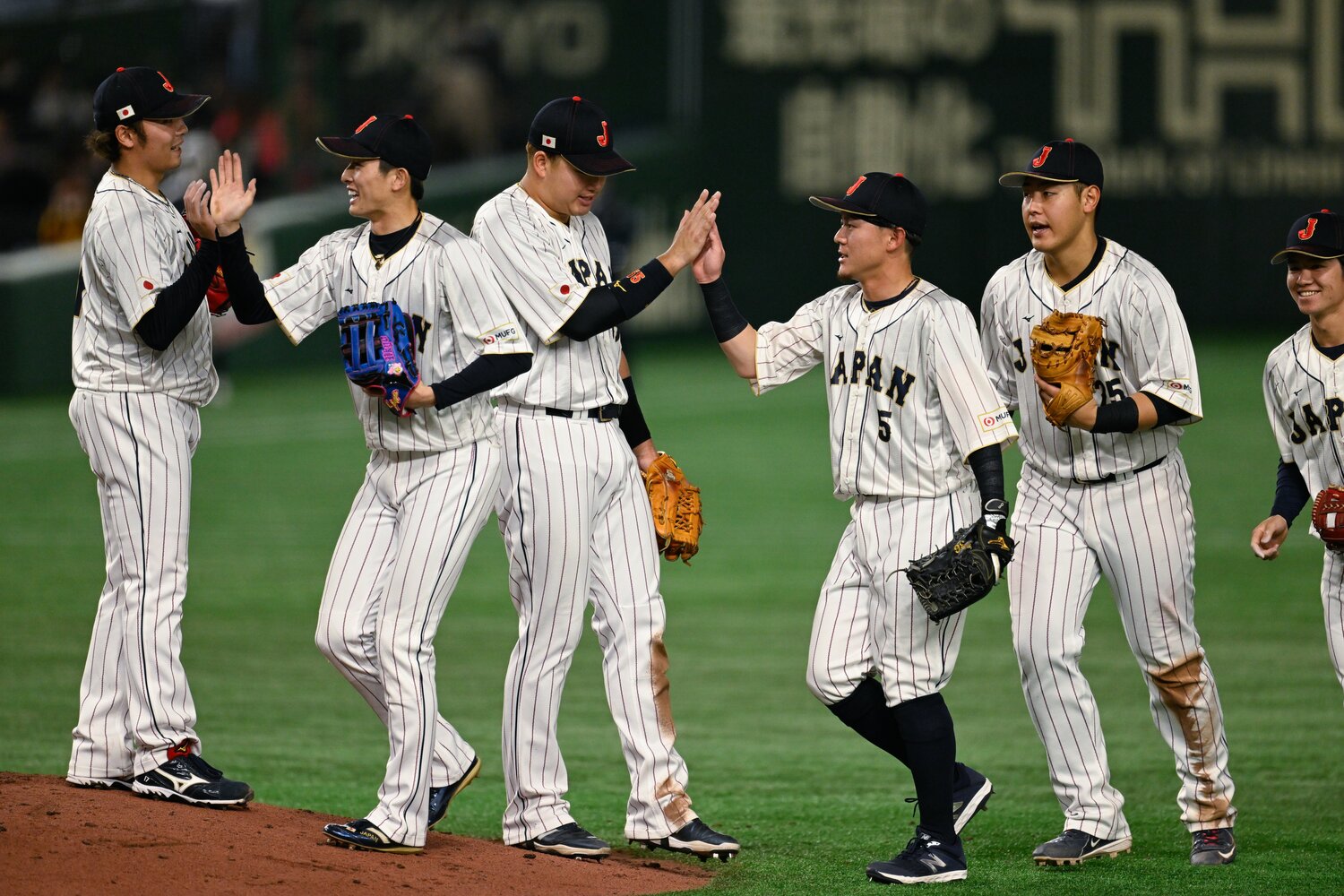 手前でハイタッチをする周東と牧原　©Nanae Suzuki