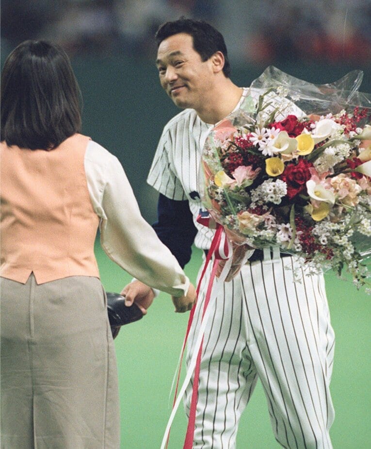 1997年5月28日ダイエー戦、セ・パ両リーグ1000安打を達成。花束で祝福を受ける落合　©KYODO