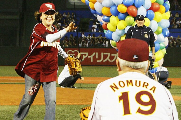 楽天監督時代、始球式で沙知代さんのボールを受けるノムさん。スポーツ紙には追悼のコラムが溢れていた。 ／ photograph by Kyodo News