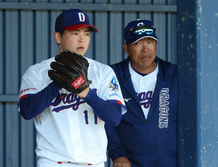 沖縄キャンプ、ブルペンで投球練習するドラ1中西聖輝を見守る井上監督　©JIJI PRESS