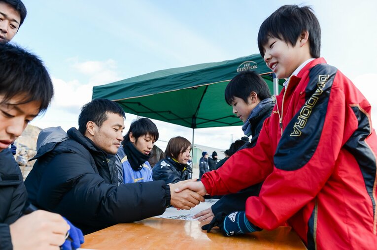 今野泰幸と握手する当時小6の菅原龍之助（2013年東北人魂のサッカー教室）©︎Miki Sano