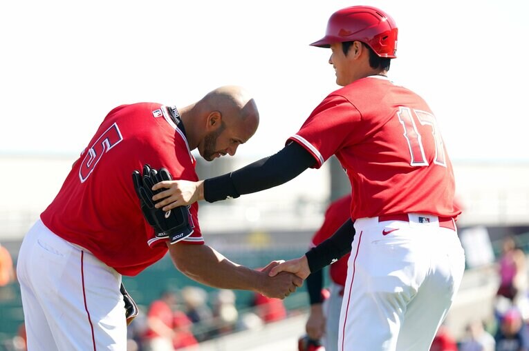 深々とお辞儀で大谷と握手するプホルス。大谷は照れ笑い？　©Getty Images