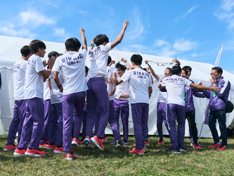 予選通過が発表され、一気に喜びを爆発させる選手たち。代理監督（一番右）は手を顔に近づけ…　©Yuki Suenaga