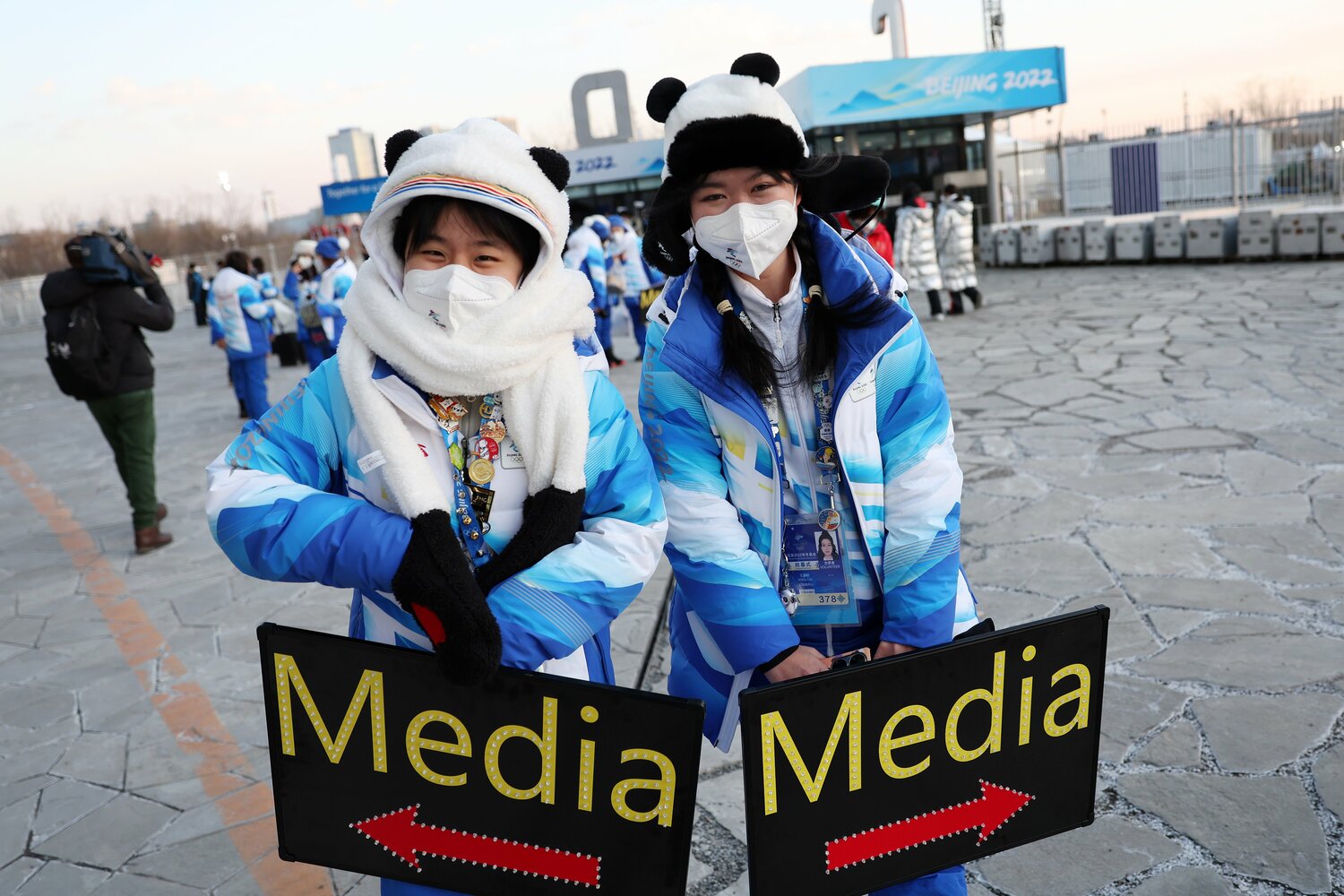 「Media」と書かれた案内板をもって誘導係をするボランティアスタッフ　©Getty Images