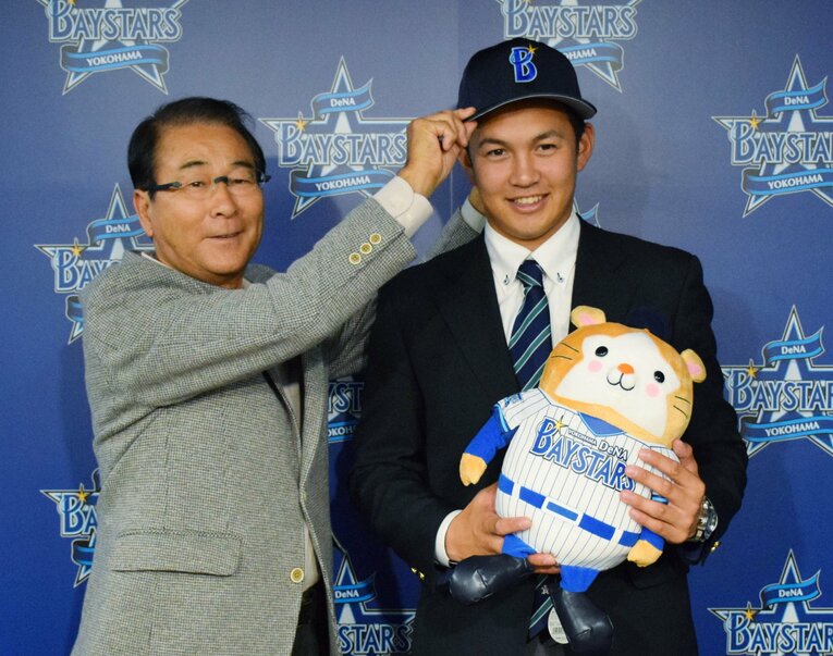 DeNAと仮契約し、笑顔を見せる亜大の山崎康晃（右）と高田繁GM　©JIJI PRESS