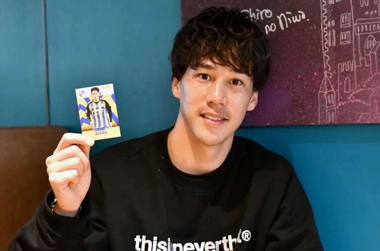 インタビュー後、自身のトレーディングカードを手に微笑む江坂　©Kang Hyeong Gi