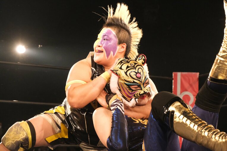 スリーパーホールドに苦悶の表情を浮かべるクイーン
