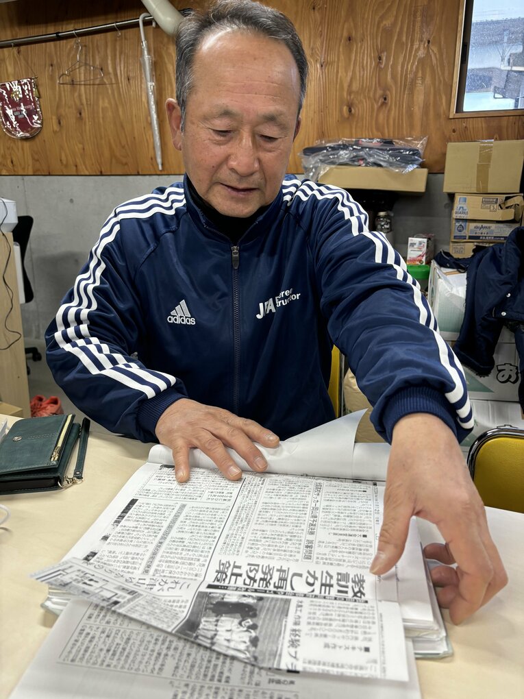 22年、大切に保管していた当時の新聞記事を見ながら審判人生を振り返る青木さん　©︎Takahito Ando