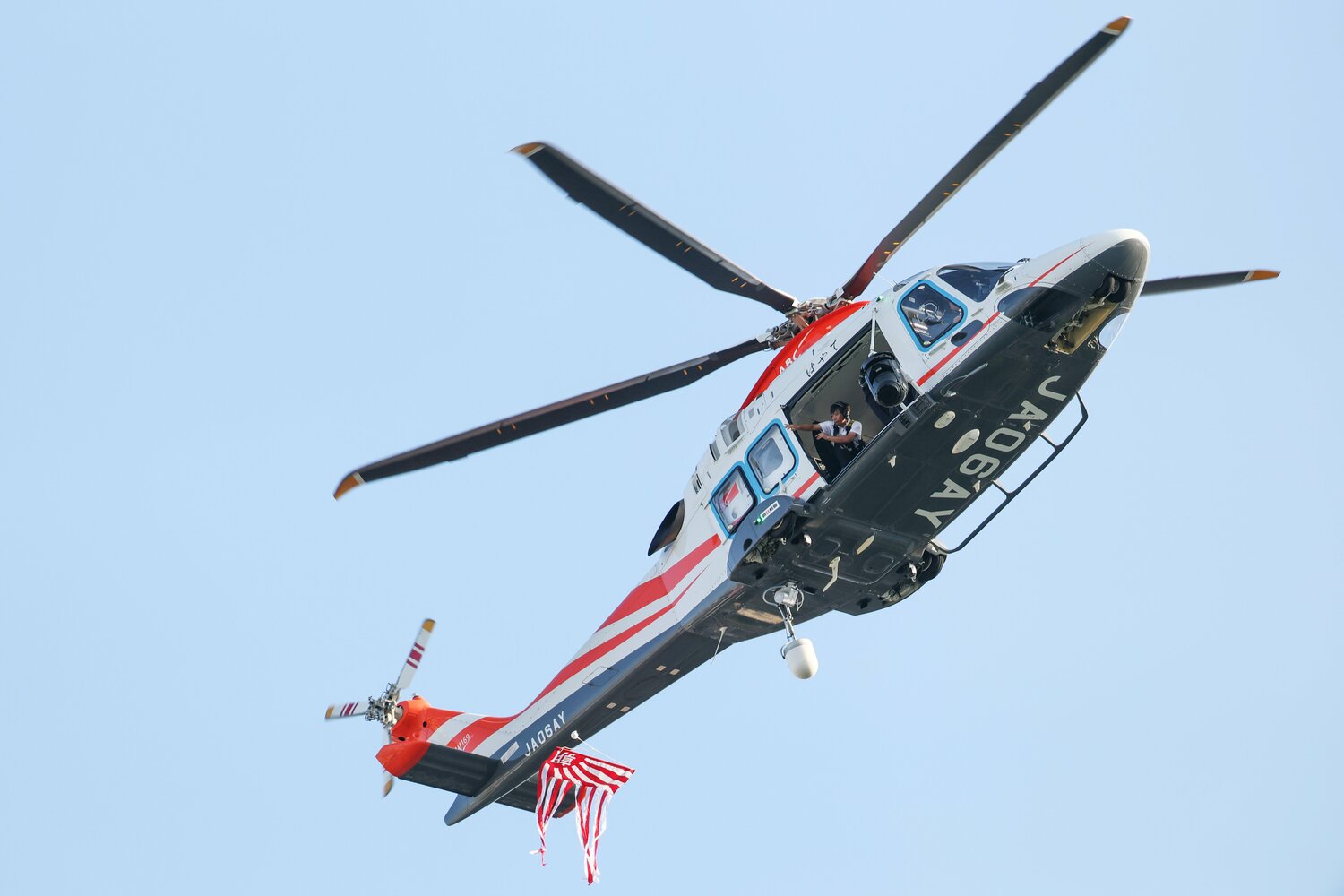 始球式のボールを運んできたヘリコプター。1回目、ボールは落下せず失敗。2回目で成功した(写真中央下、ボールは朝日新聞の社旗にくくりつけられている)