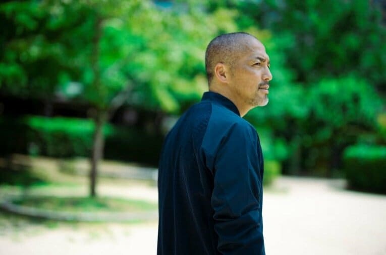 NumberとASICSが共作したジャケットを着る小野伸二 ／ photograph by Tomosuke Imai