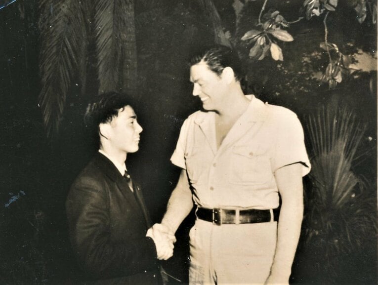 元水泳選手でハリウッド俳優のジョニー・ワイズミュラーと握手する田中茂樹（本人提供）