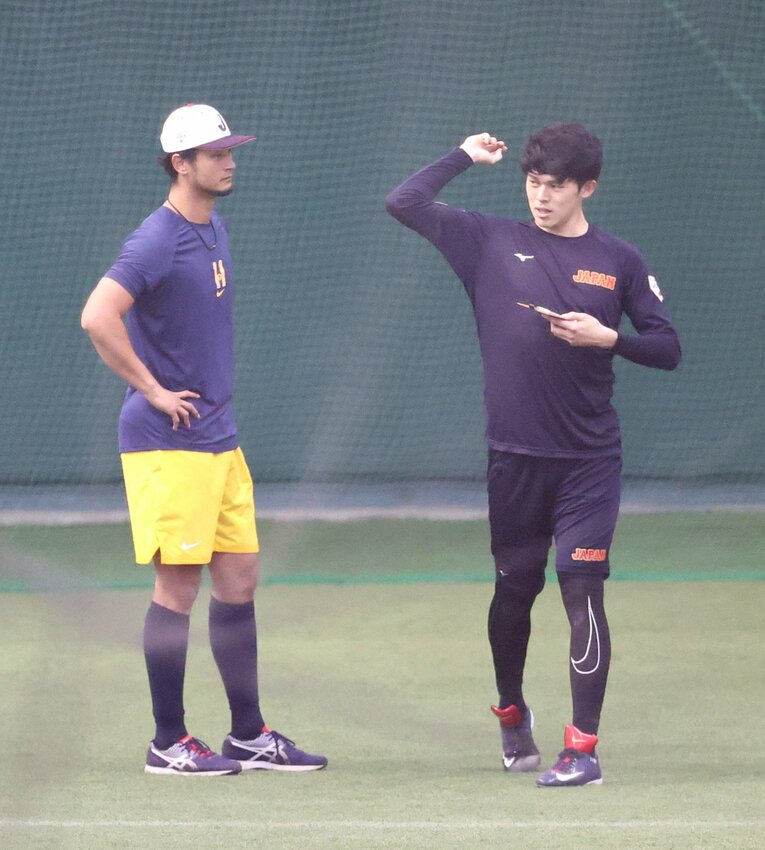 昨年2月のWBCキャンプで。ダルビッシュ有の指導を受ける佐々木朗希　©JIJI PRESS