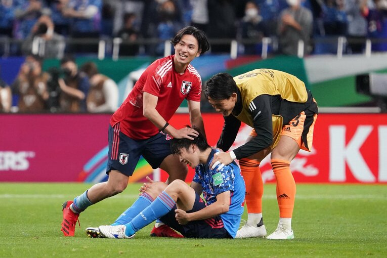 貴重な先制弾を決めた田中碧は、足をつりながらもフル出場。試合終了のホイッスルと同時にピッチに倒れ込んだ田中を、南野拓実と谷晃生が労う　©Getty Images