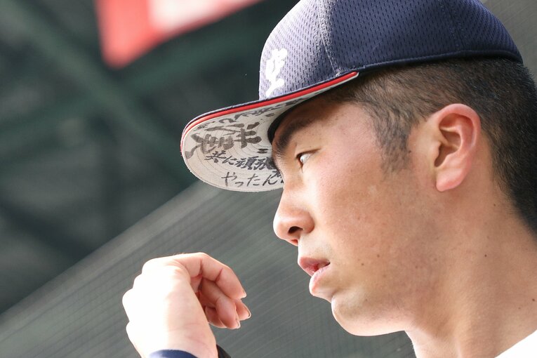 日本航空石川の選手の帽子に書かれた「共に頑張ろう」などの文字　©JIJI PRESS