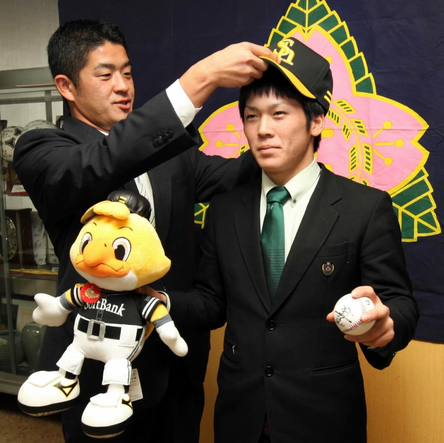 2010年11月、ソフトバンク福山龍太郎スカウト（当時）に帽子をかぶせてもらう甲斐拓也（写真／大分合同新聞社）©︎KYODO