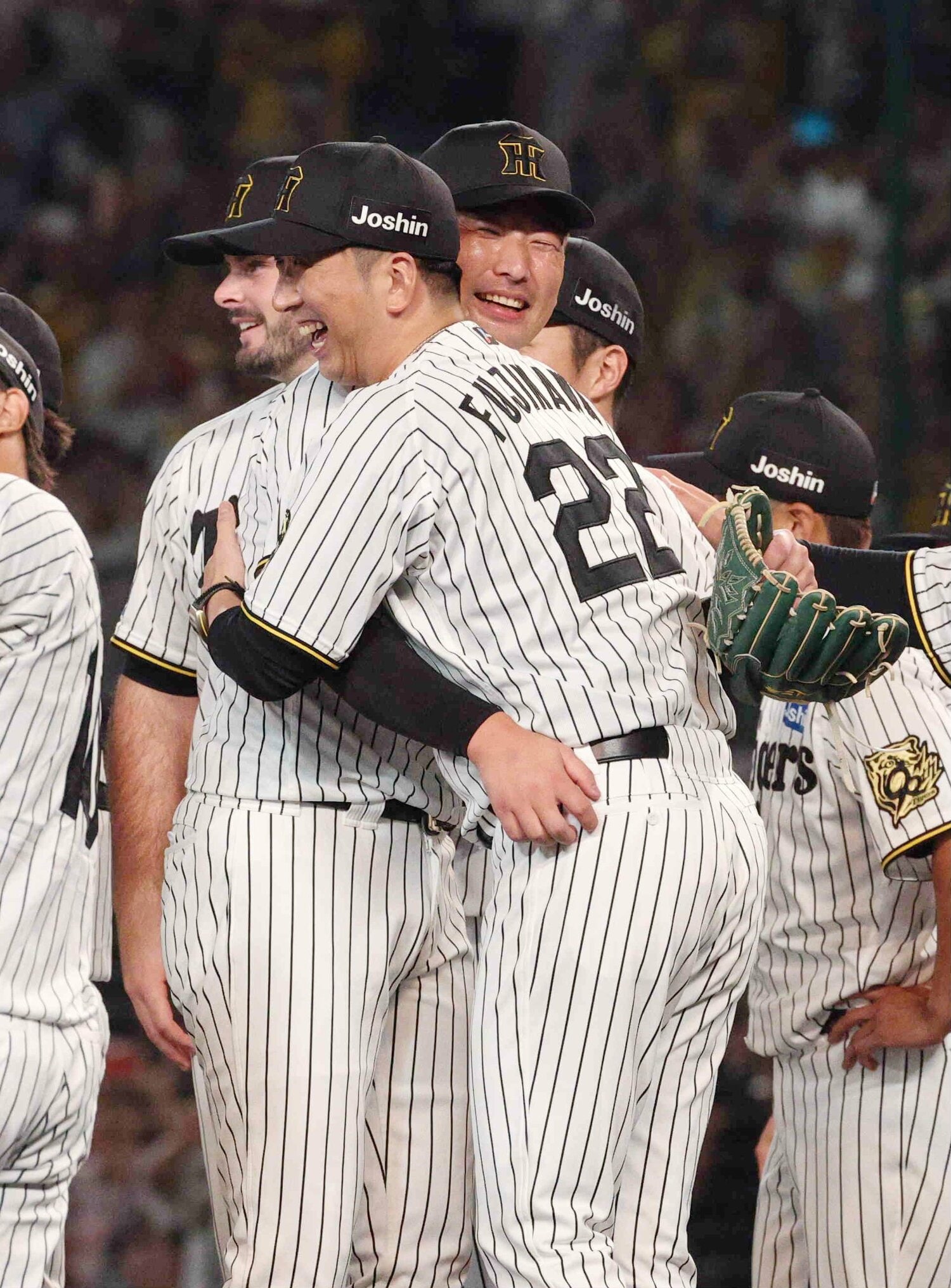 優勝を果たし、笑顔で抱き合う藤川監督と抑えの岩崎優　©JIJI PRESS