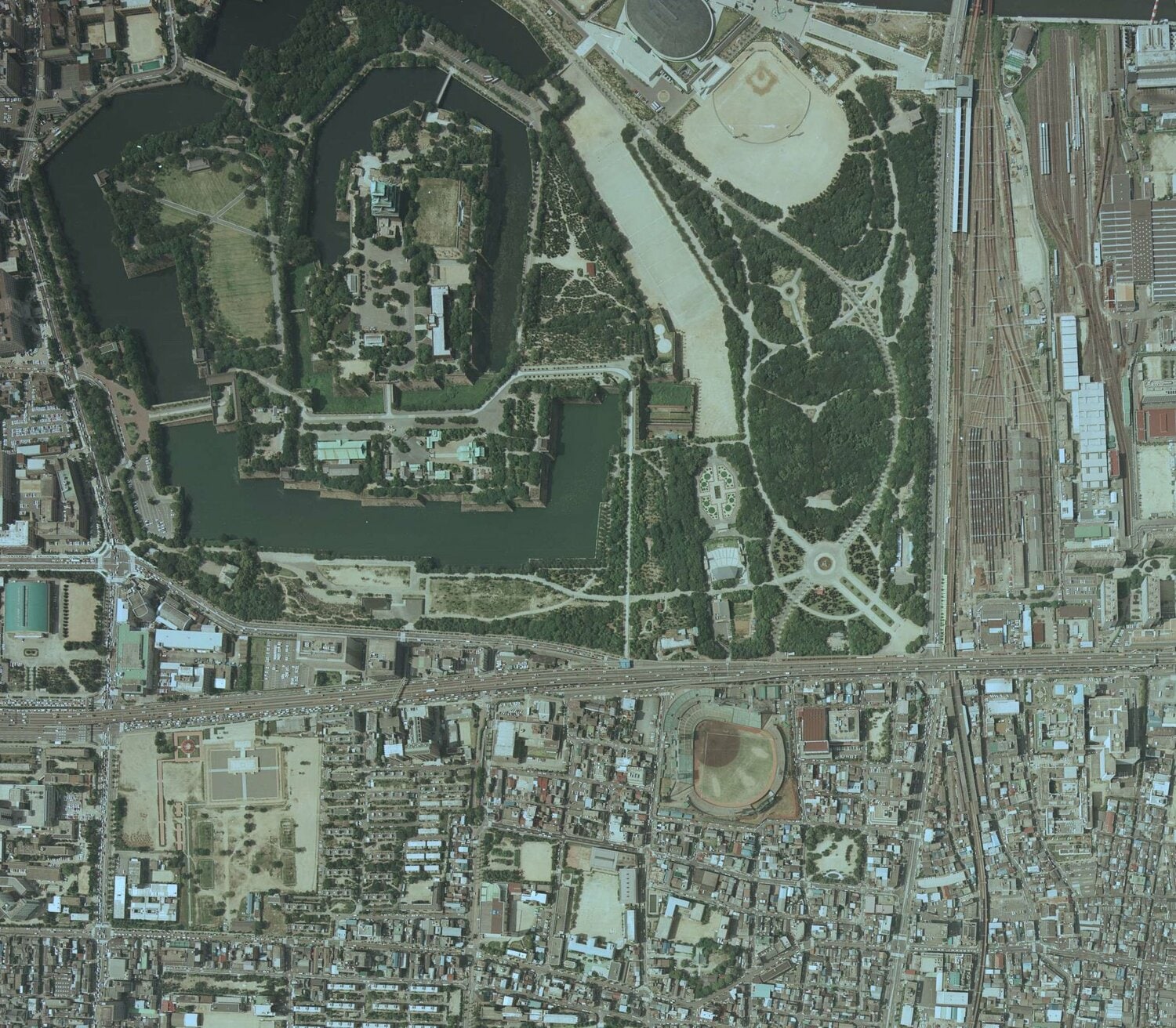 こちらは、1985年の森ノ宮駅、大阪城（左上）付近の航空写真。中央大通沿い、大阪城公園の向かいに日生球場が確認できる。森ノ宮駅は右下。右上には車両基地も見える　出典：国土地理院の空中写真