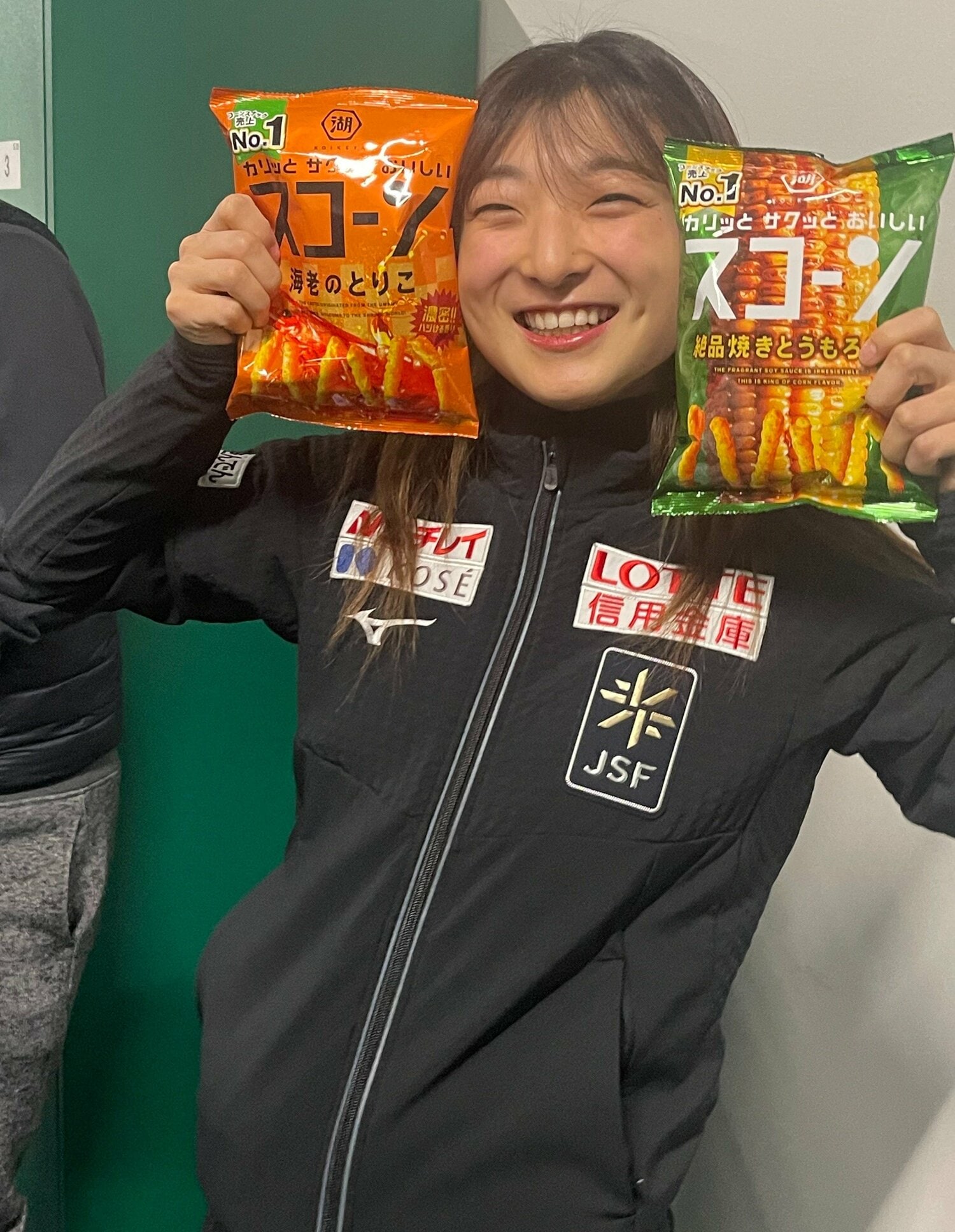 持参したお菓子を持って笑顔の坂本　©Akiko Tamura