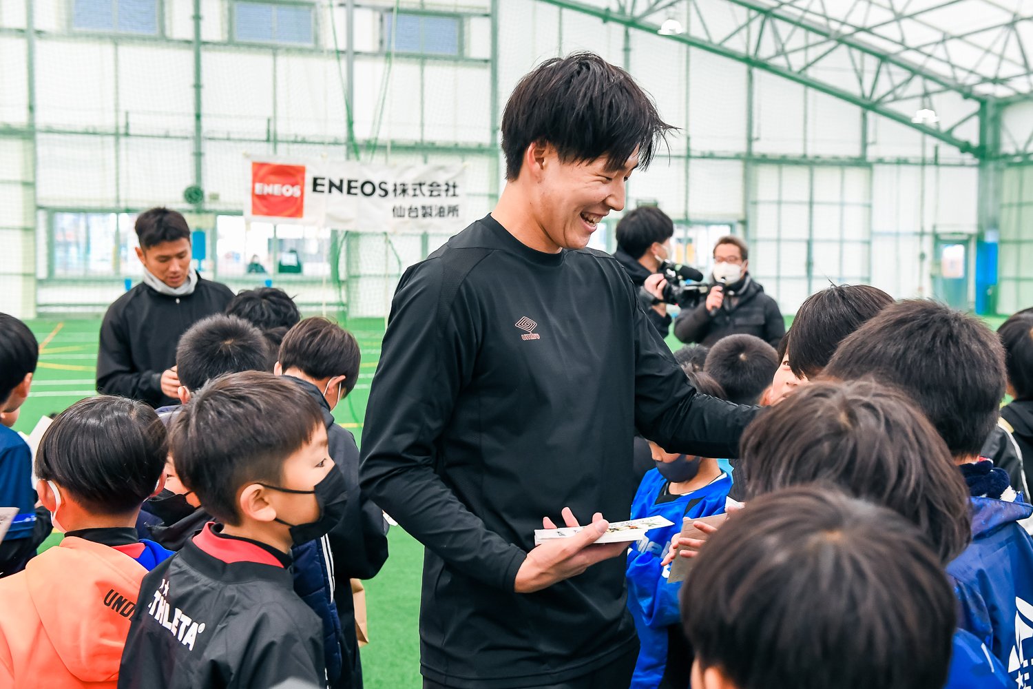子どもたちに囲まれる菅原。Jリーグのピッチで活躍する姿を子どもたちに見せらせるか（2023年1月）©︎Miki Sano