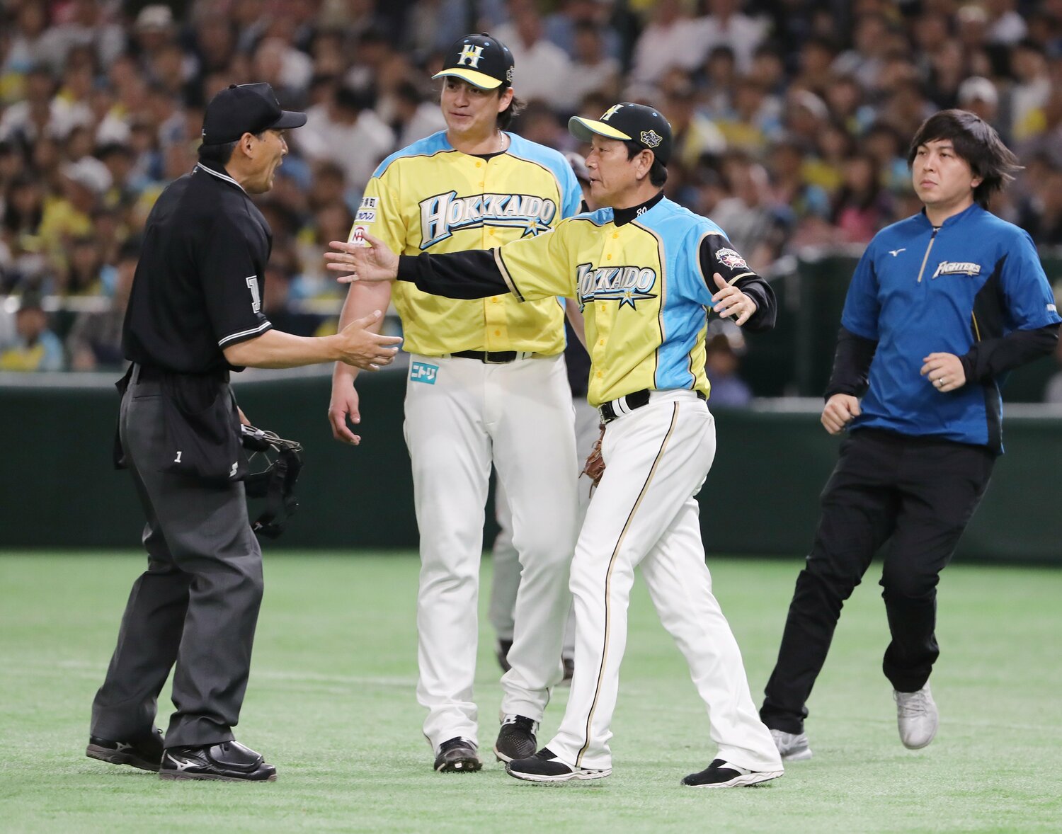 2017年、日本ハムでの通訳時代の貴重な一コマ。担当していたルイス・メンドーサが危険球の判定を受け、球審に詰め寄る栗山英樹監督と共にベンチから飛び出した水原通訳（右）　©︎JIJI PRESS　