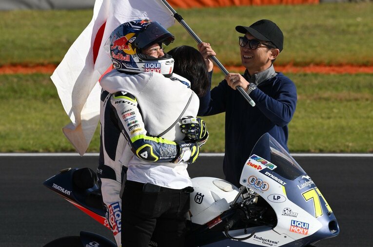 ウイニングランの途中、両親と抱き合って喜ぶ佐々木歩夢。渡された日章旗は22年前に加藤大治郎が使ったもの ／ photograph by Satoshi Endo