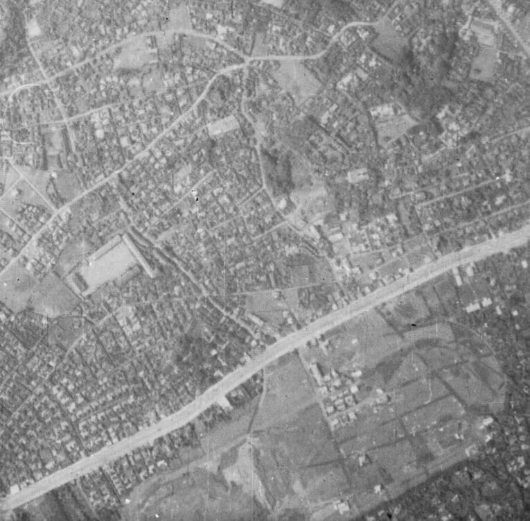 1936年の航空写真。大きな幹線道路が目黒通り。そしてその下の大きな土地が目黒競馬場（の跡地）である。1934年に東京競馬場に移転となり、すでに家が建ち始めているのが分かる　出典：国土地理院の空中写真